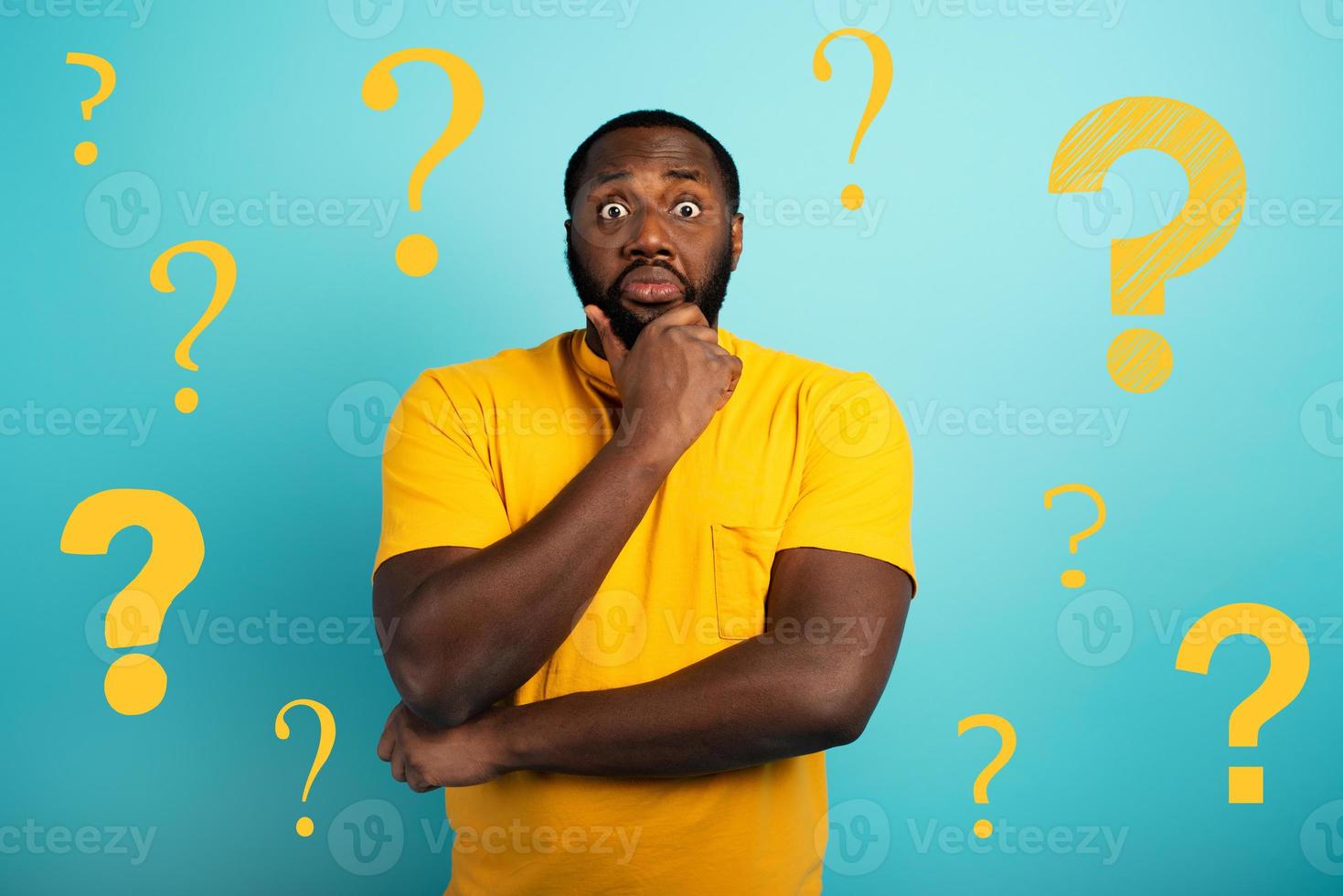 Confuse and pensive expression of a boy with many questions . cyan colored background photo