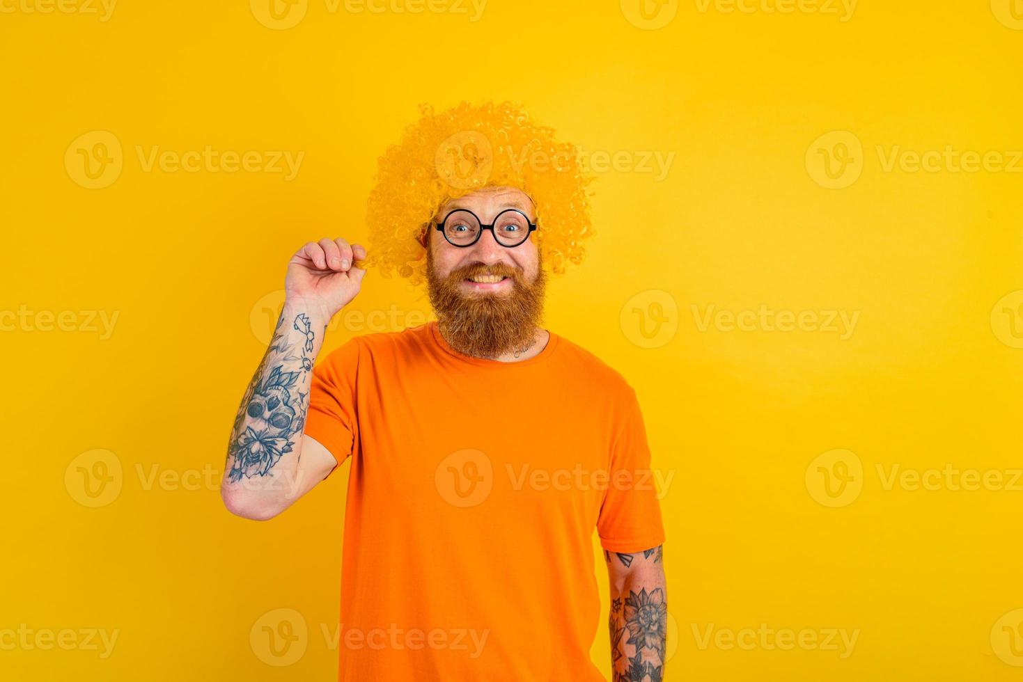 Happy man with beard, yellow wig and glasses photo