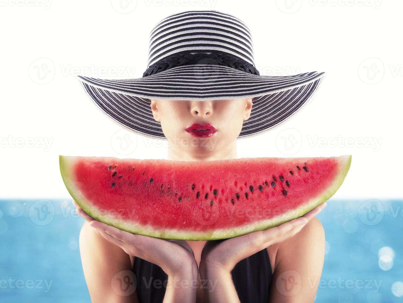 Girl in swimsuit with red watermelon in hand photo