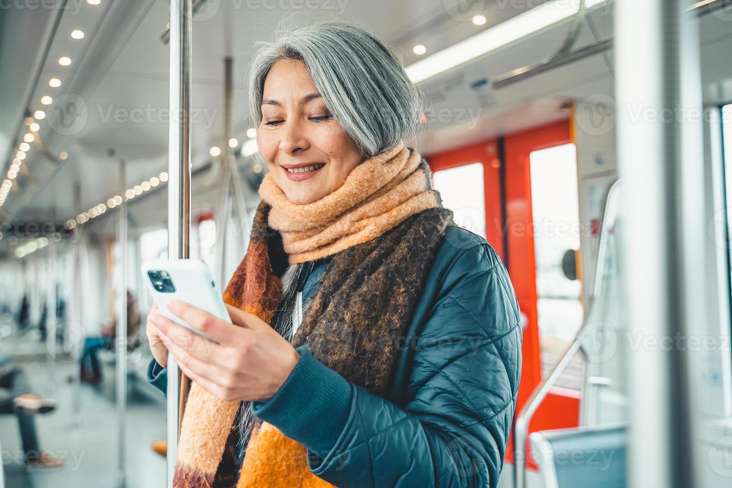 Senior woman send message with a mobile phone in a train photo