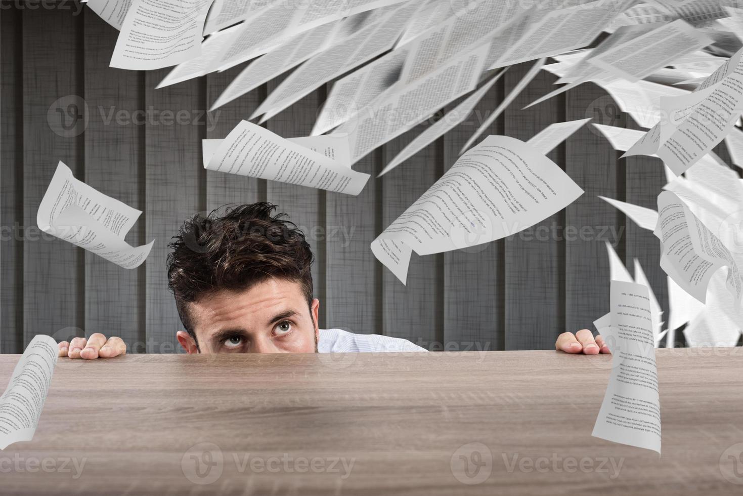 Businessman afraid under the desk. concept of overwork photo