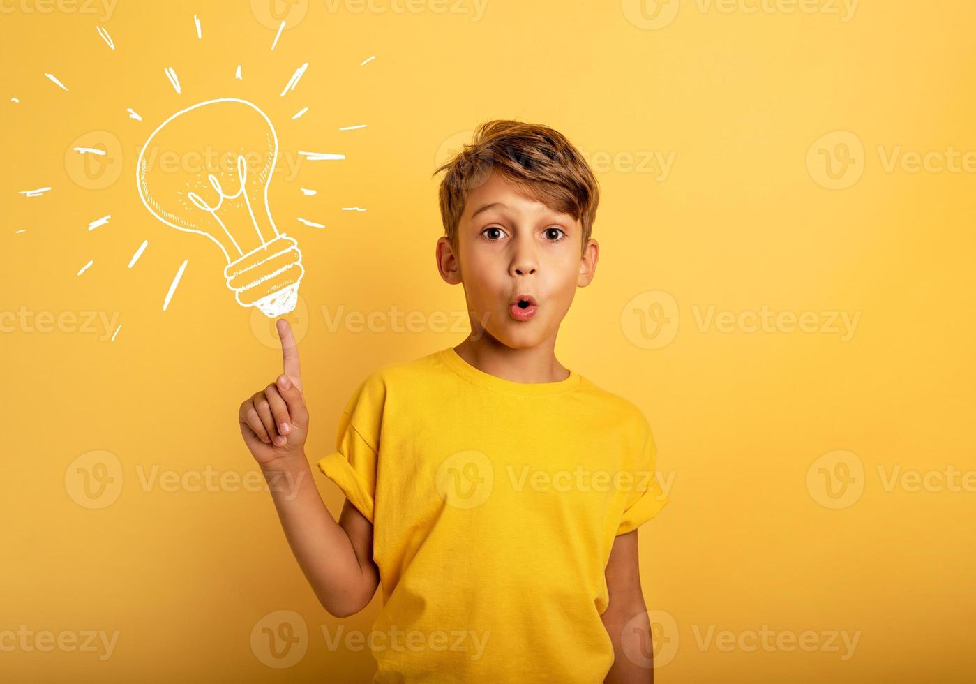 Emotional Child have a big idea. Surprised and amazed face expression. Yellow background photo