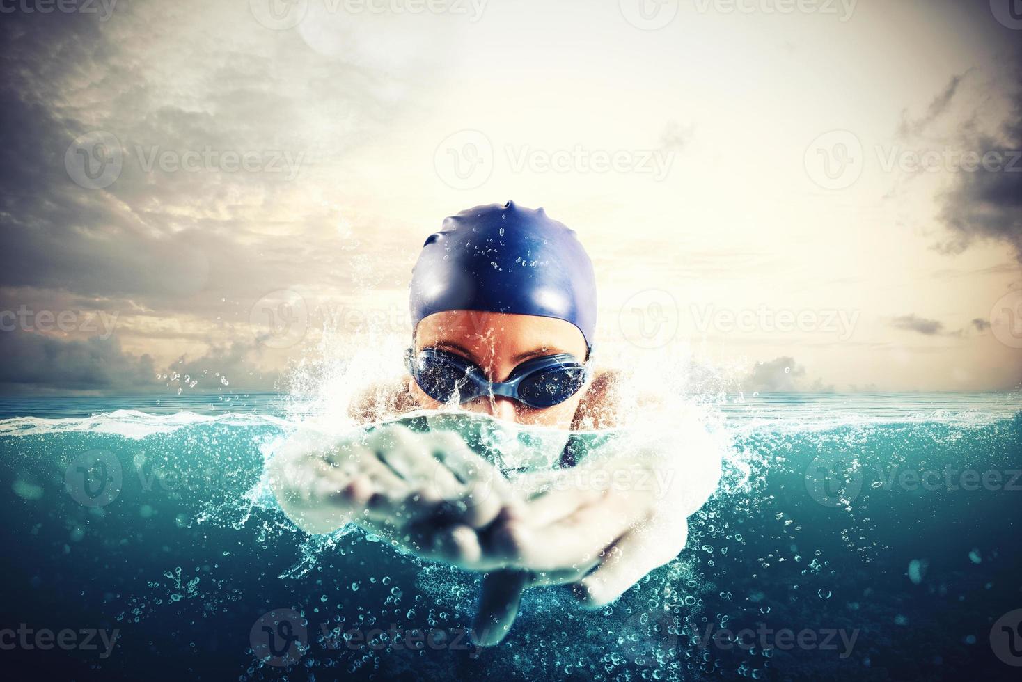 Athlete swims in a blue deep water photo