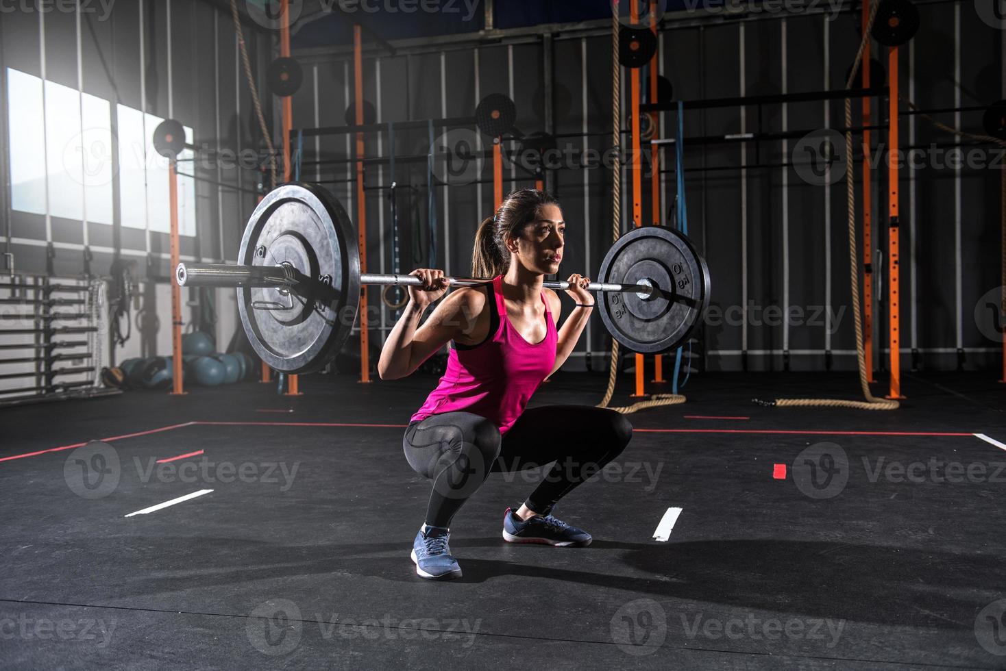 atlético niña trabajos fuera a el gimnasio con un barra con pesas foto