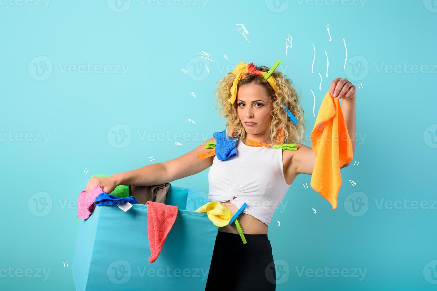 Tired housewife full of clothes and cloths to clean. cyan background photo