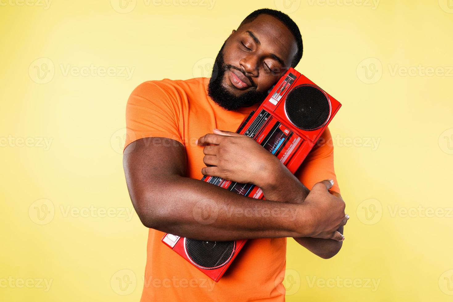 Man hugs an old stereo. he love the music. yellow background photo