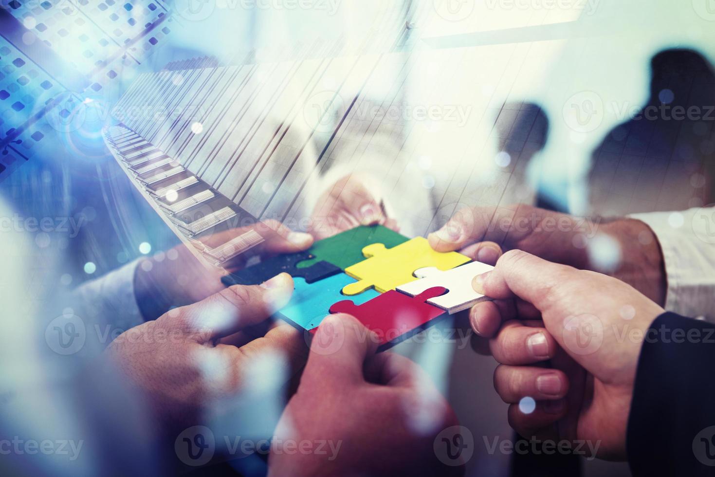 Business people join puzzle pieces in office. Concept of teamwork and partnership. double exposure with light effects photo