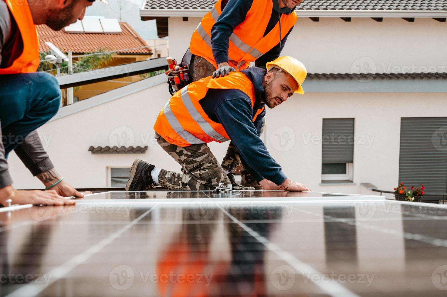 Workers assemble energy system with solar panel for electricity photo