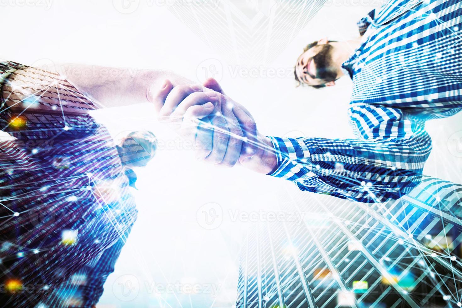 Handshaking business person in casual wear. concept of teamwork and partnership. double exposure photo