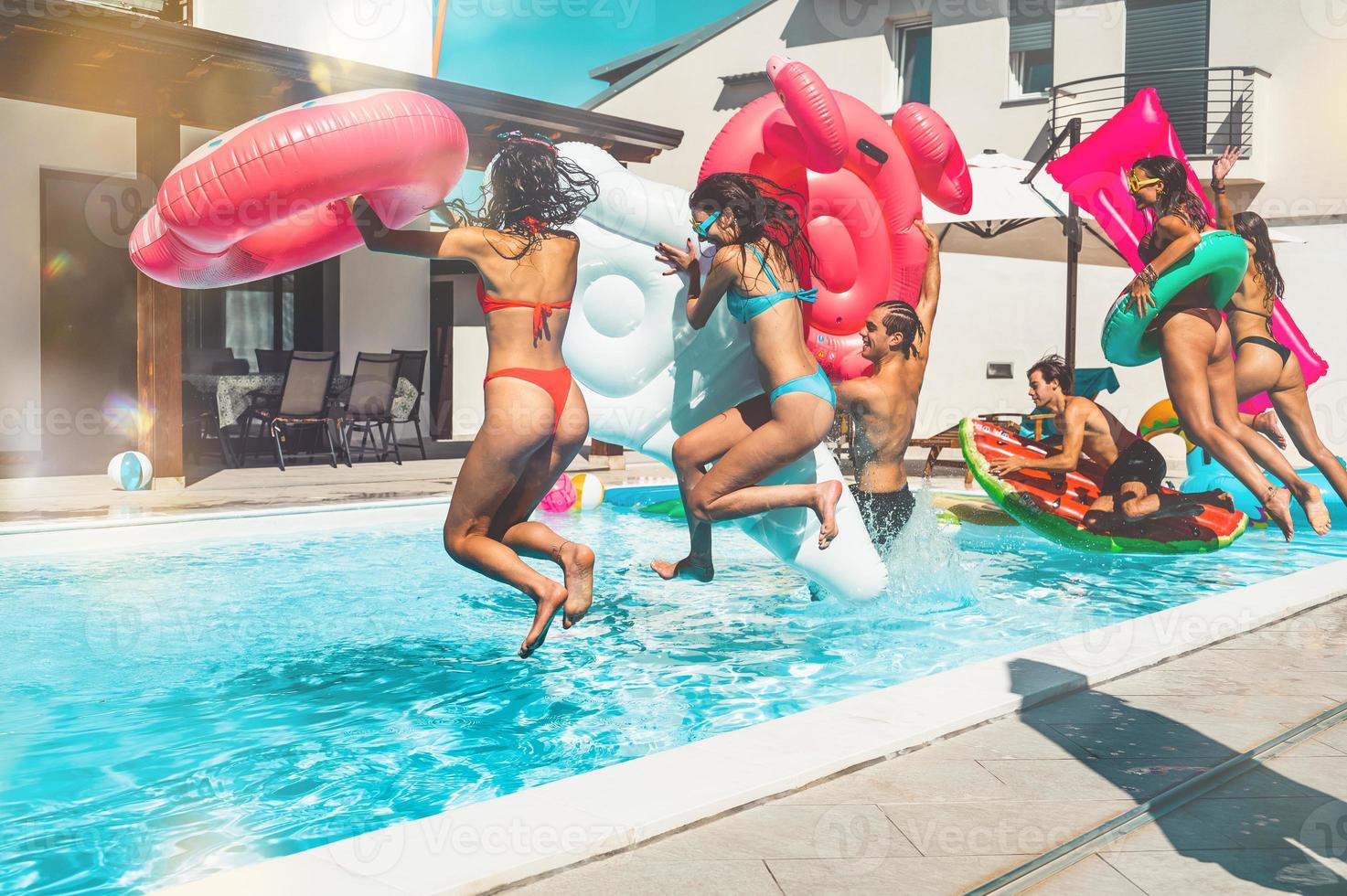 Group of friends in swimsuit enjoy in a swimming pool photo