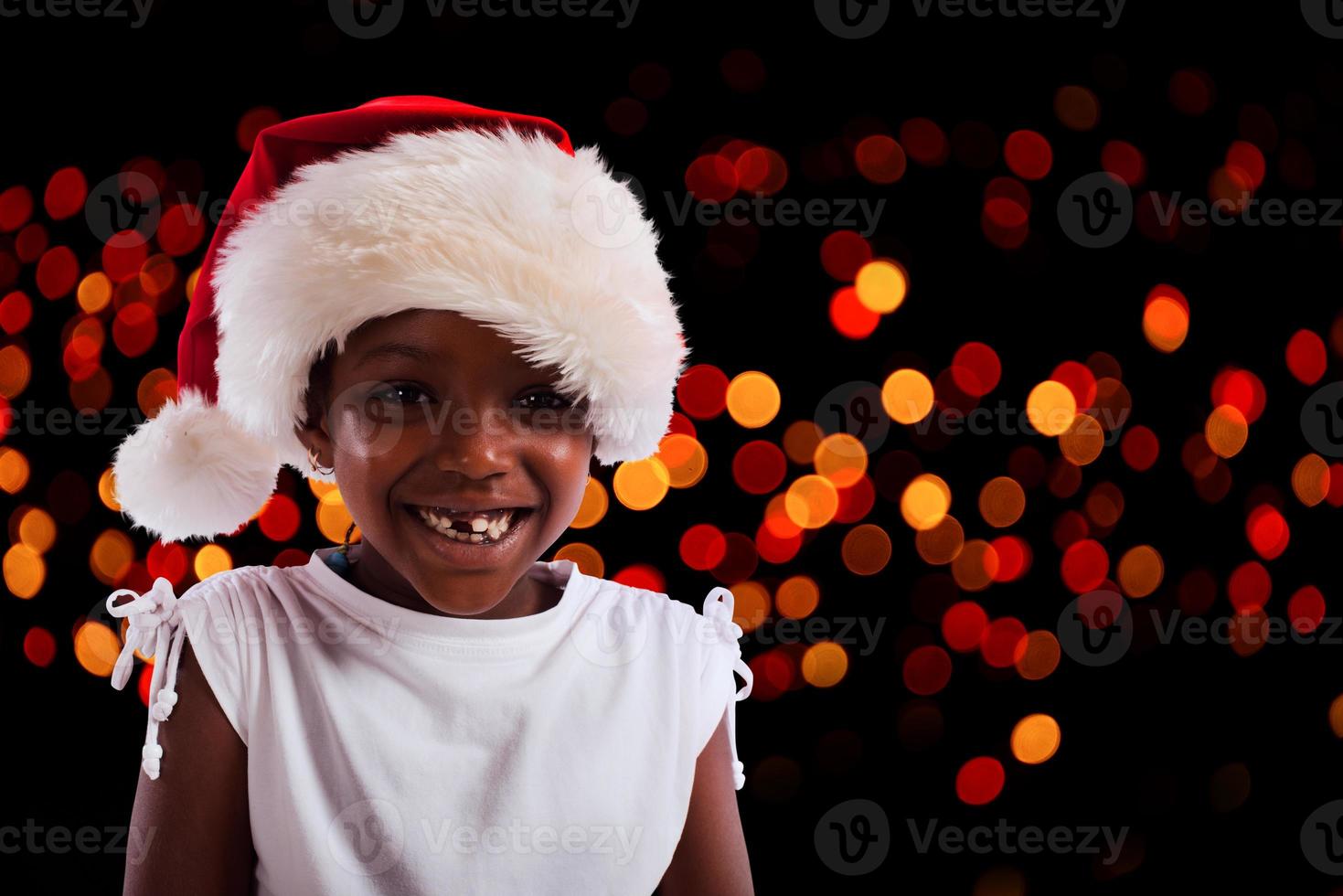 Smiling little girl with christmas hat in head photo