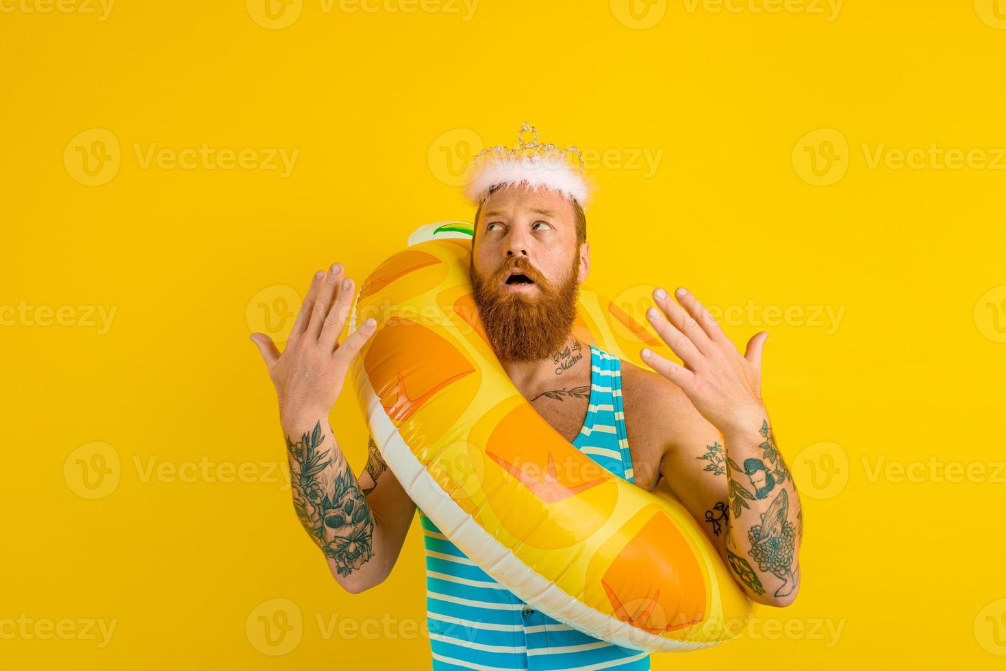 man with life buoy and princess crown feels too hot photo