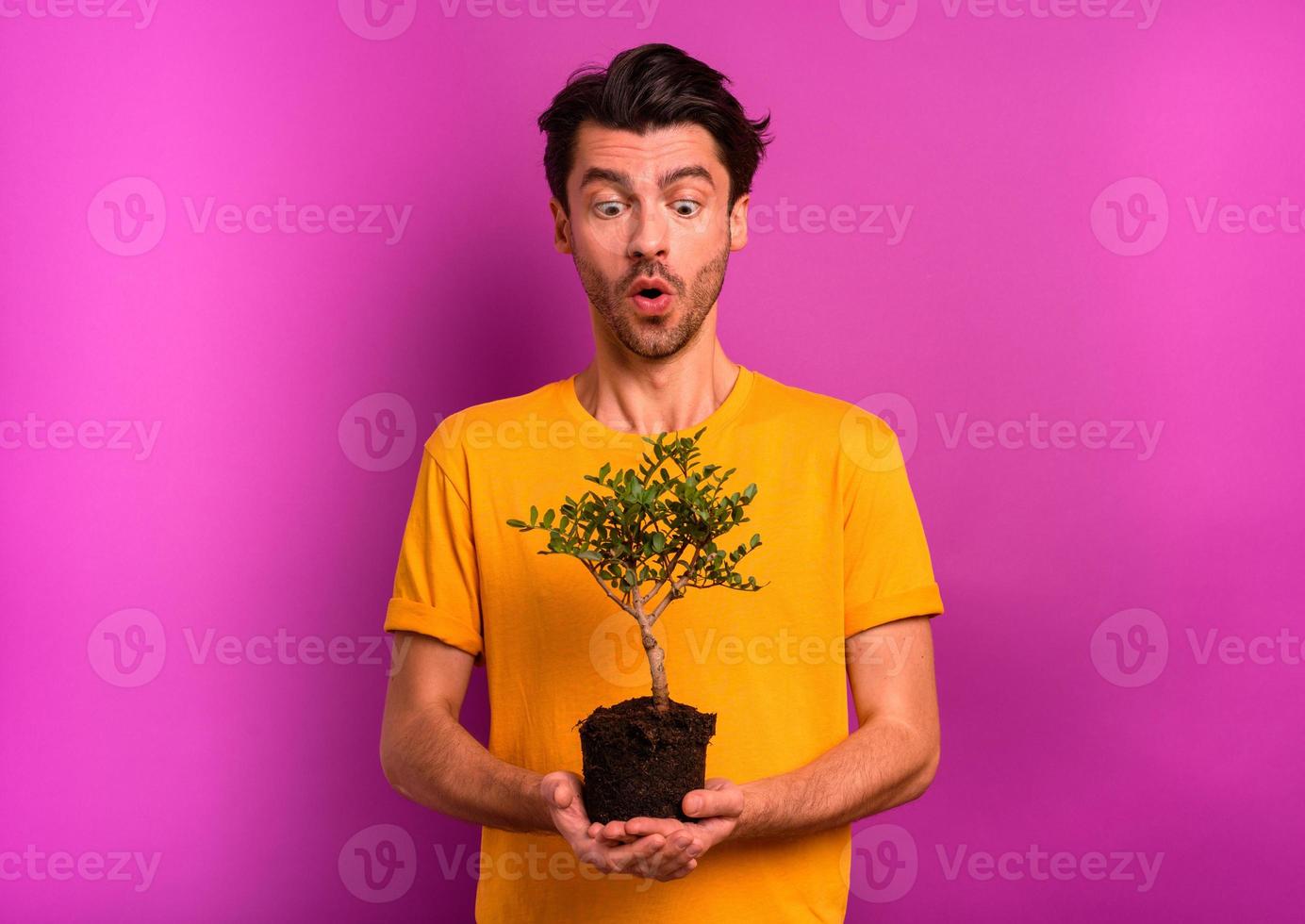 Man holds and takes care of a small tree photo