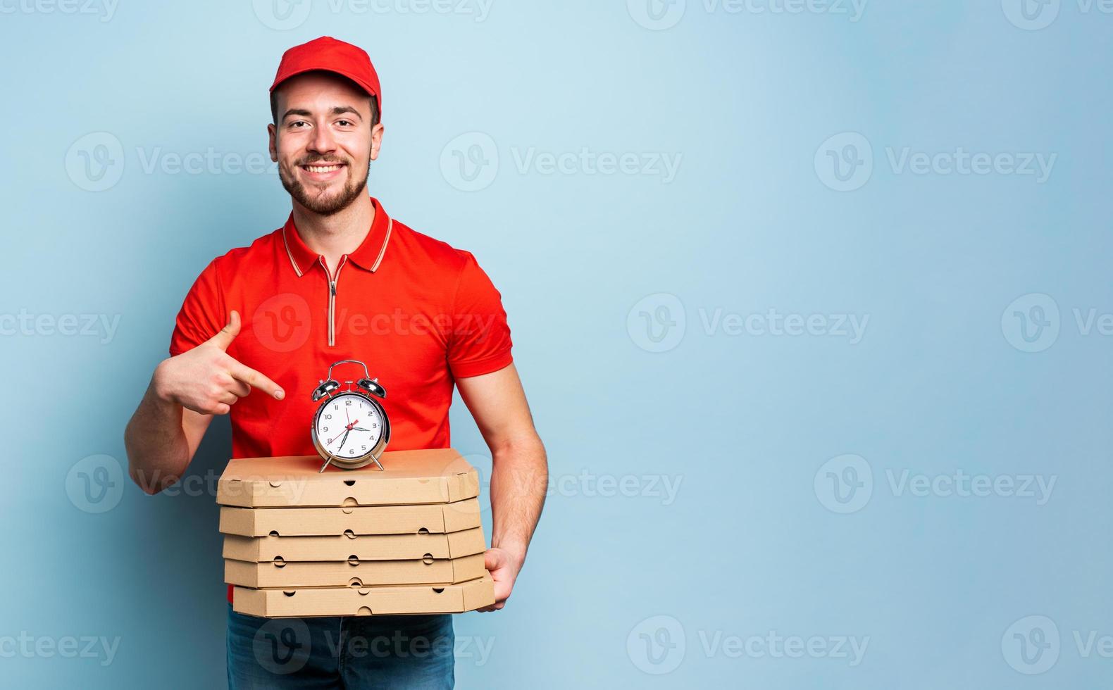 Deliveryman is punctual to deliver quickly pizzas. Cyan background photo