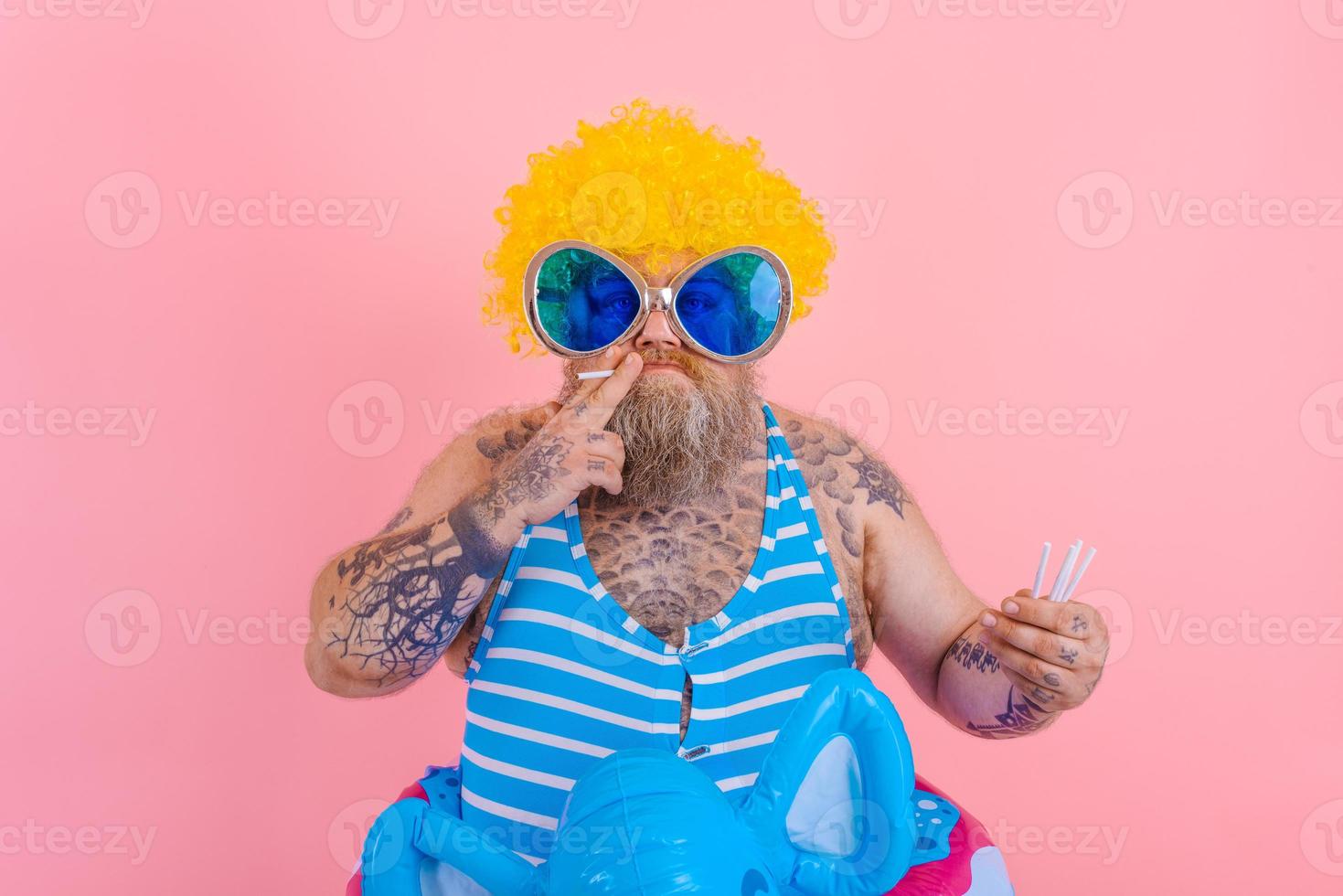 Fat serious man with beard and wig smokes cigarettes photo