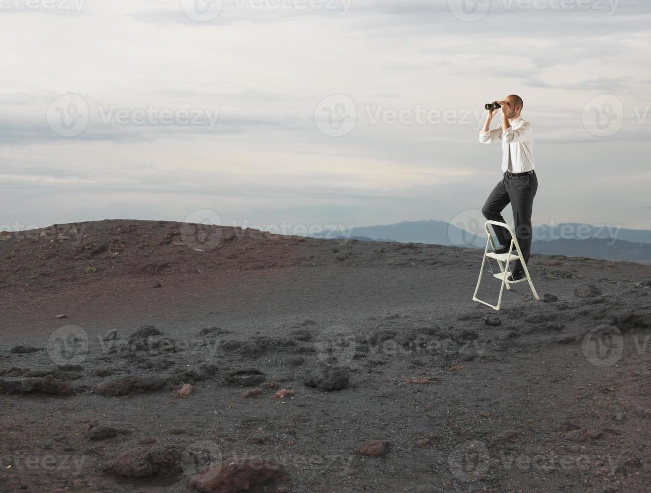 Businessman look far for new business opportunities with a telescope photo