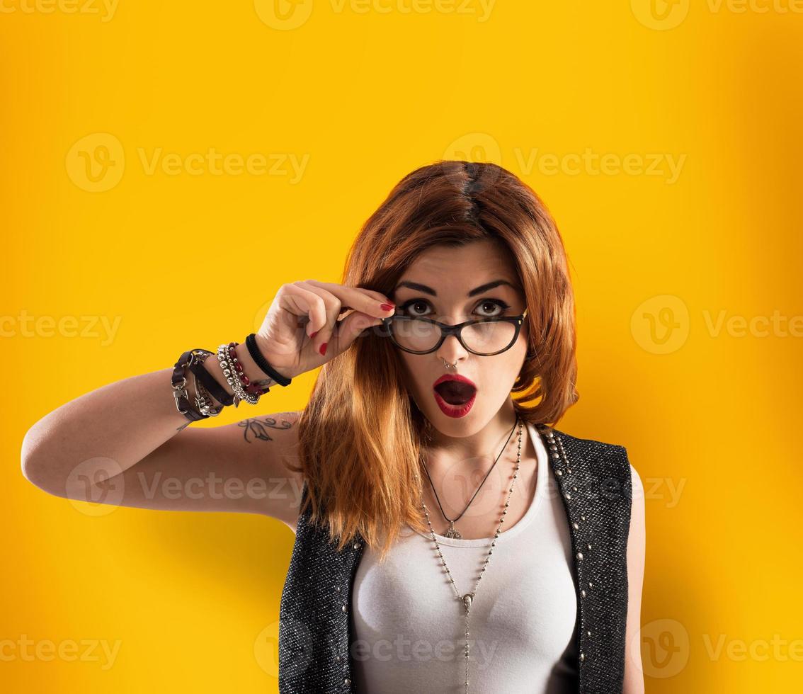 Girl has a shocked expression on yellow background photo