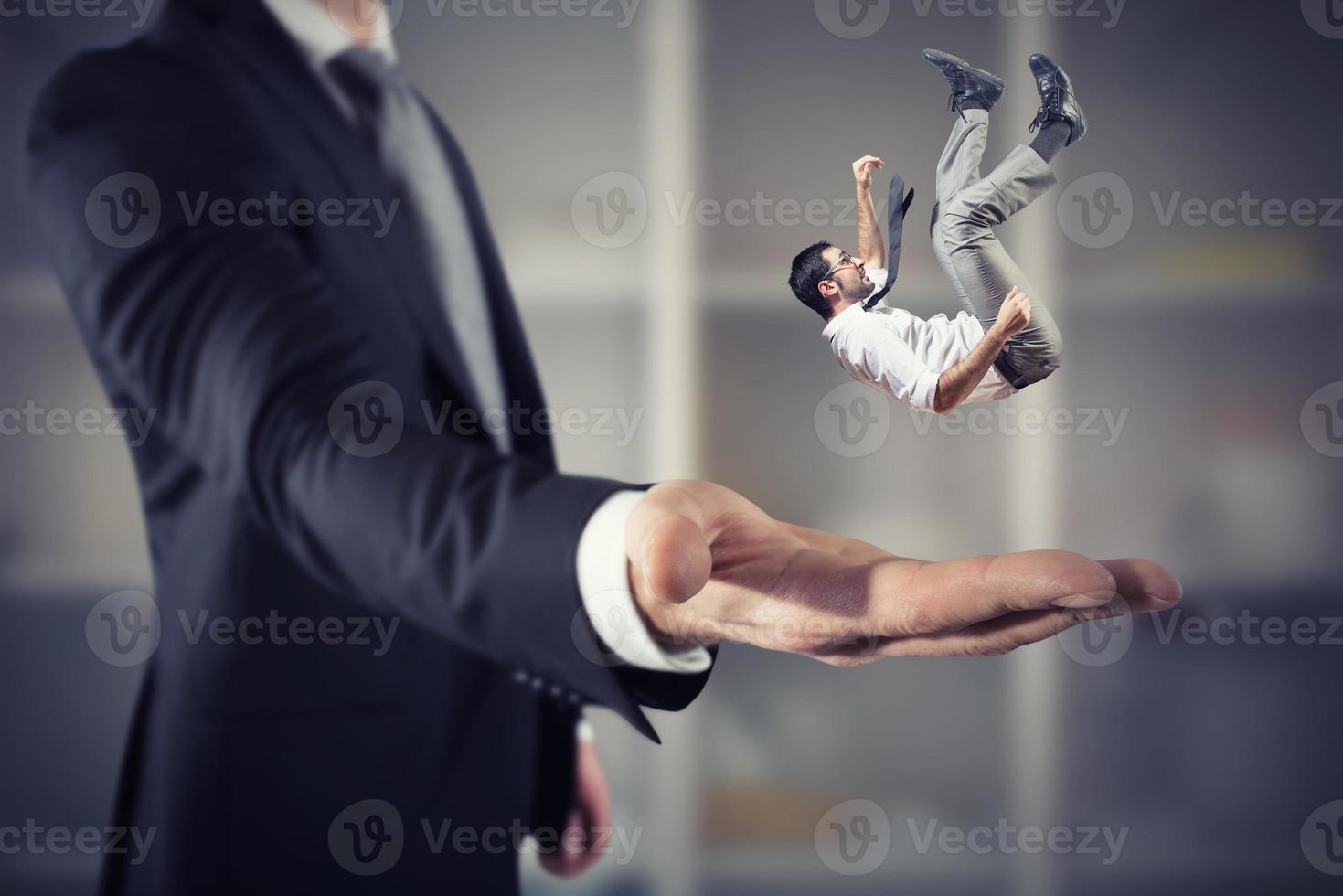 Businessman is saved from a big hand. Concept of business support and assistance photo