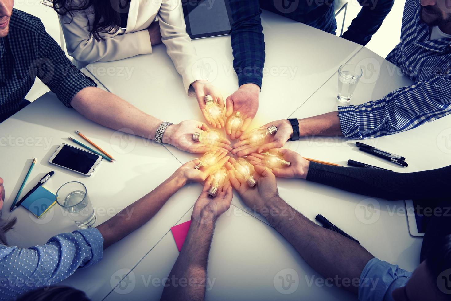Teamwork and brainstorming concept with businessmen that share an idea with a lamp. Concept of startup photo