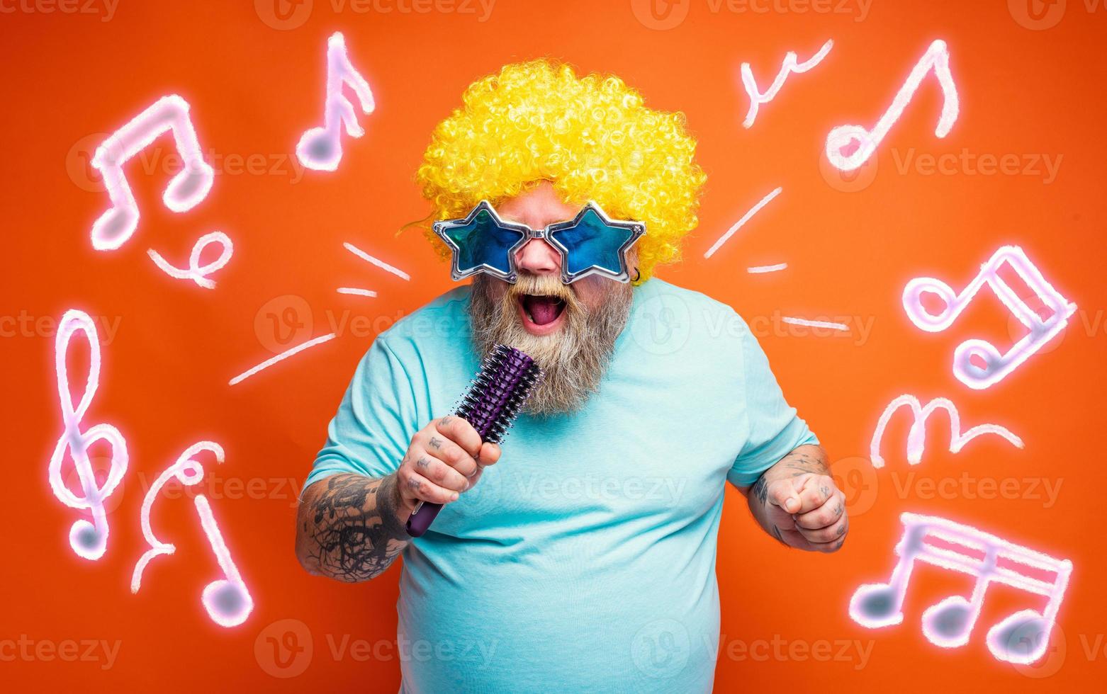 Fat man with beard, tattoos and sunglasses sings a song photo