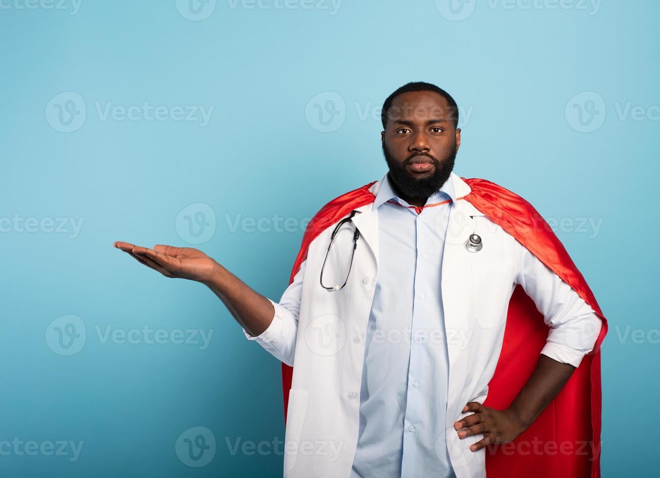 Medic like a super hero hold something. Blue background photo