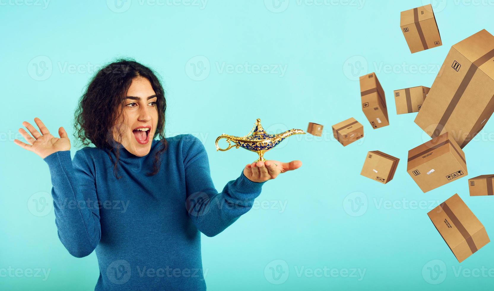 Woman is happy because she founds lamp of aladdin and receives a lot of packages. Cyan background photo