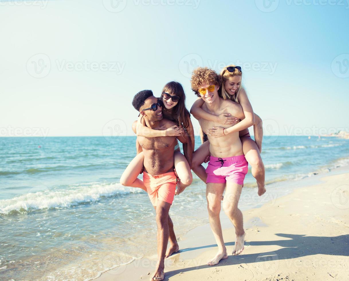 Happy smiling couples playing at the beach photo