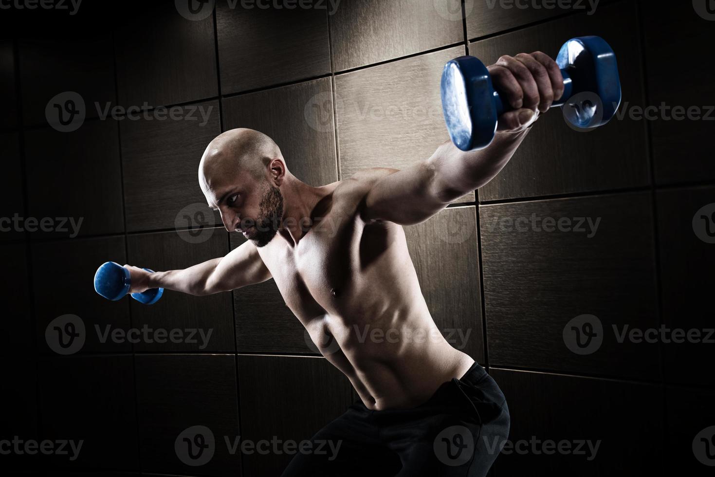 Athletic man training biceps on grunge background photo