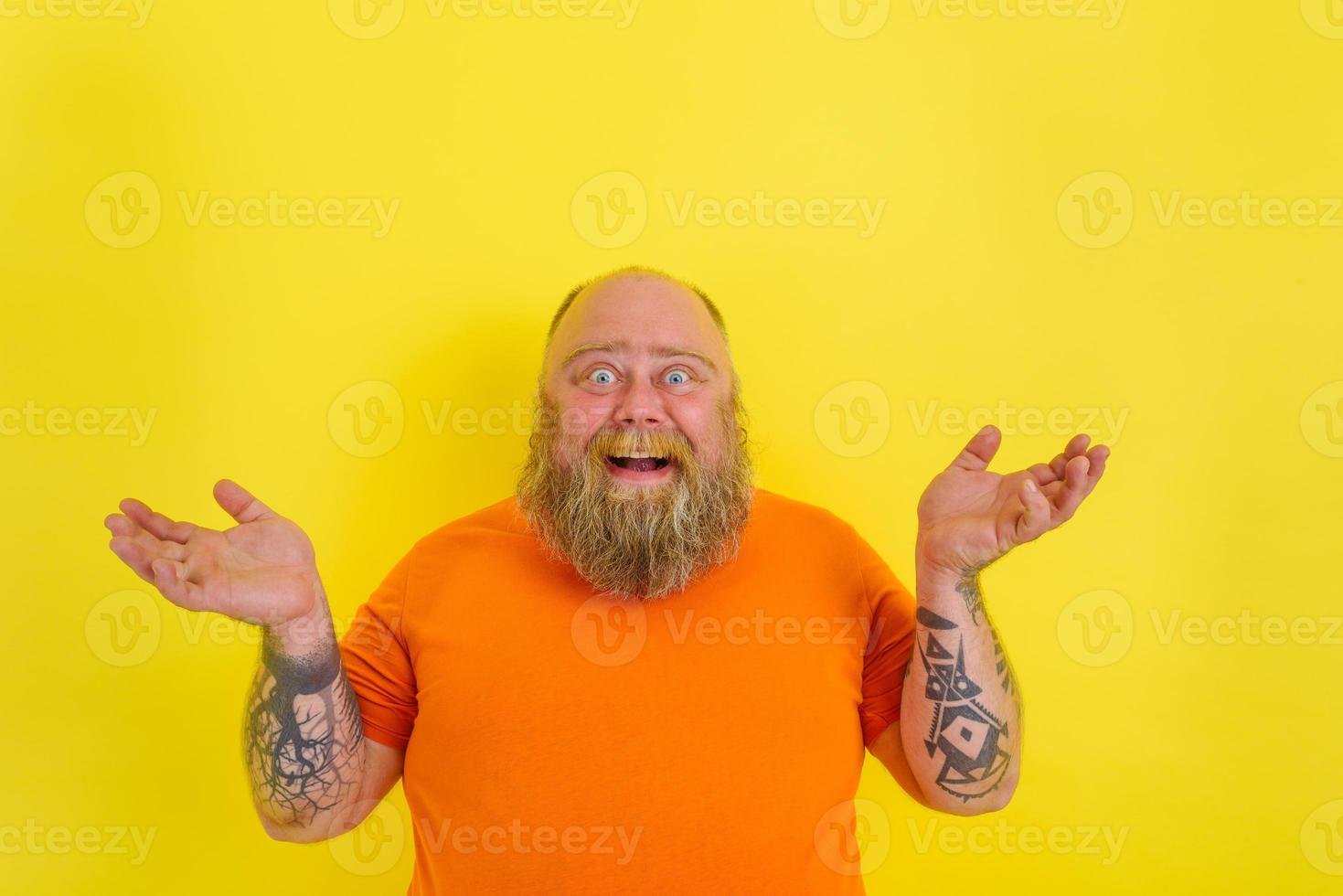 Amazed man with beard and tattoos is amazed about something photo