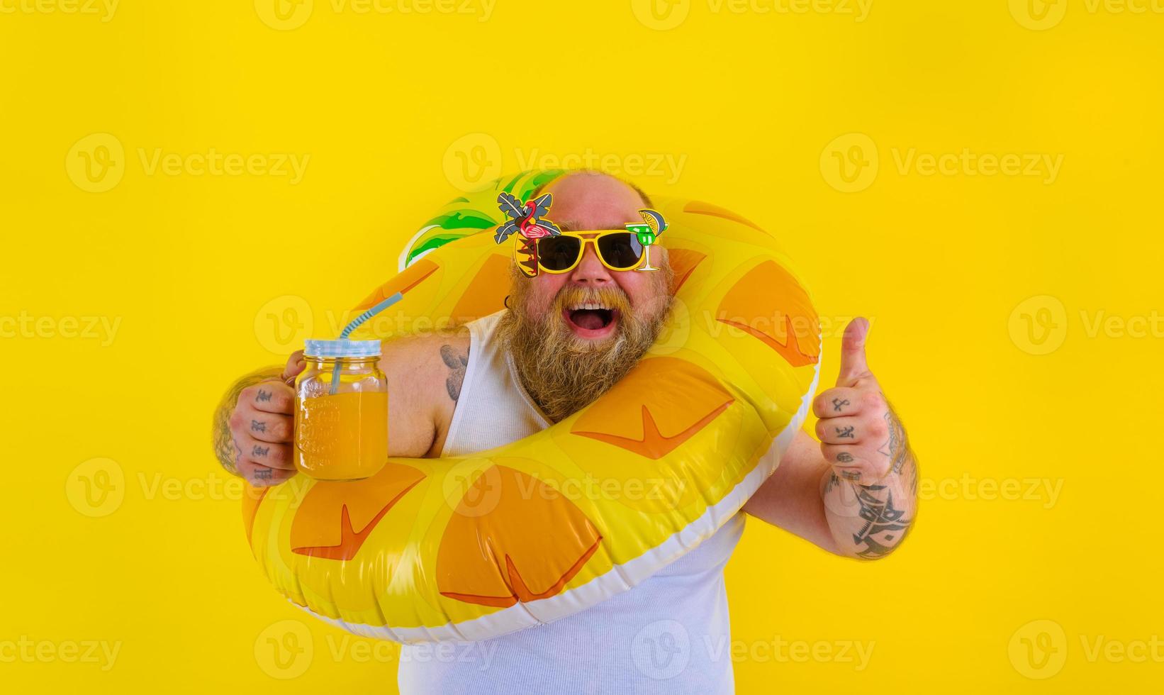 Fat happy man with wig in head is ready to swim with a donut lifesaver photo