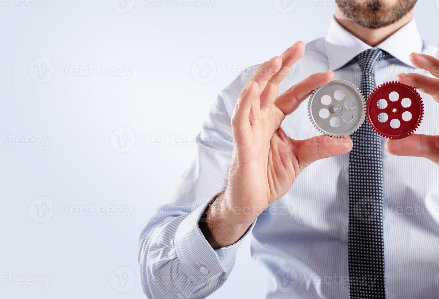 Businessman connects gears. Teamwork and partnership concept photo