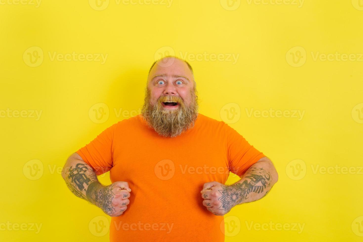 Happy man with beard and tattoos is happy about something photo