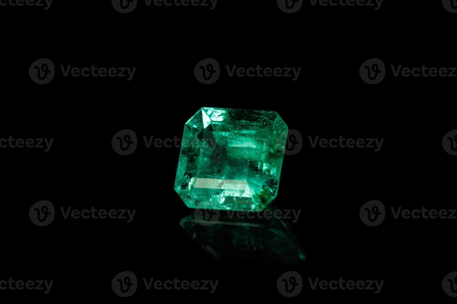 Macro mineral Emerald gemstone faceted on black background photo