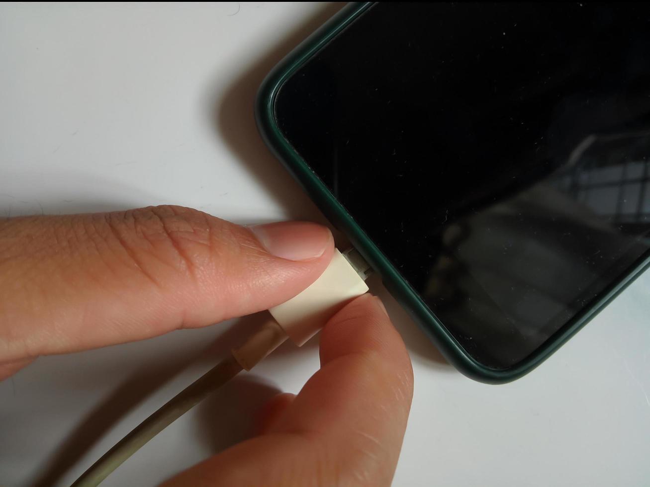 Unplug or plug in the charger's electrical connector on the smartphone photo