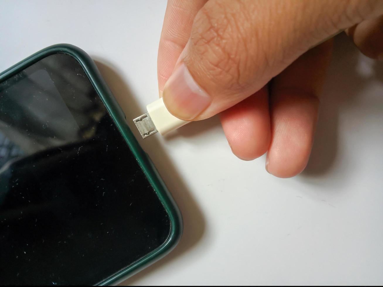 Unplug or plug in the charger's electrical connector on the smartphone photo