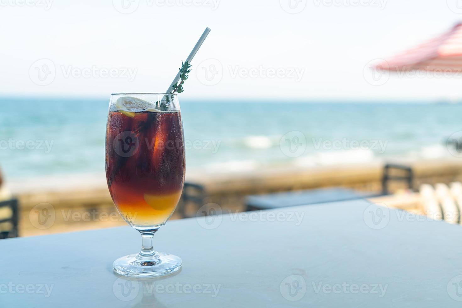 iced americano coffee peach with sea background photo