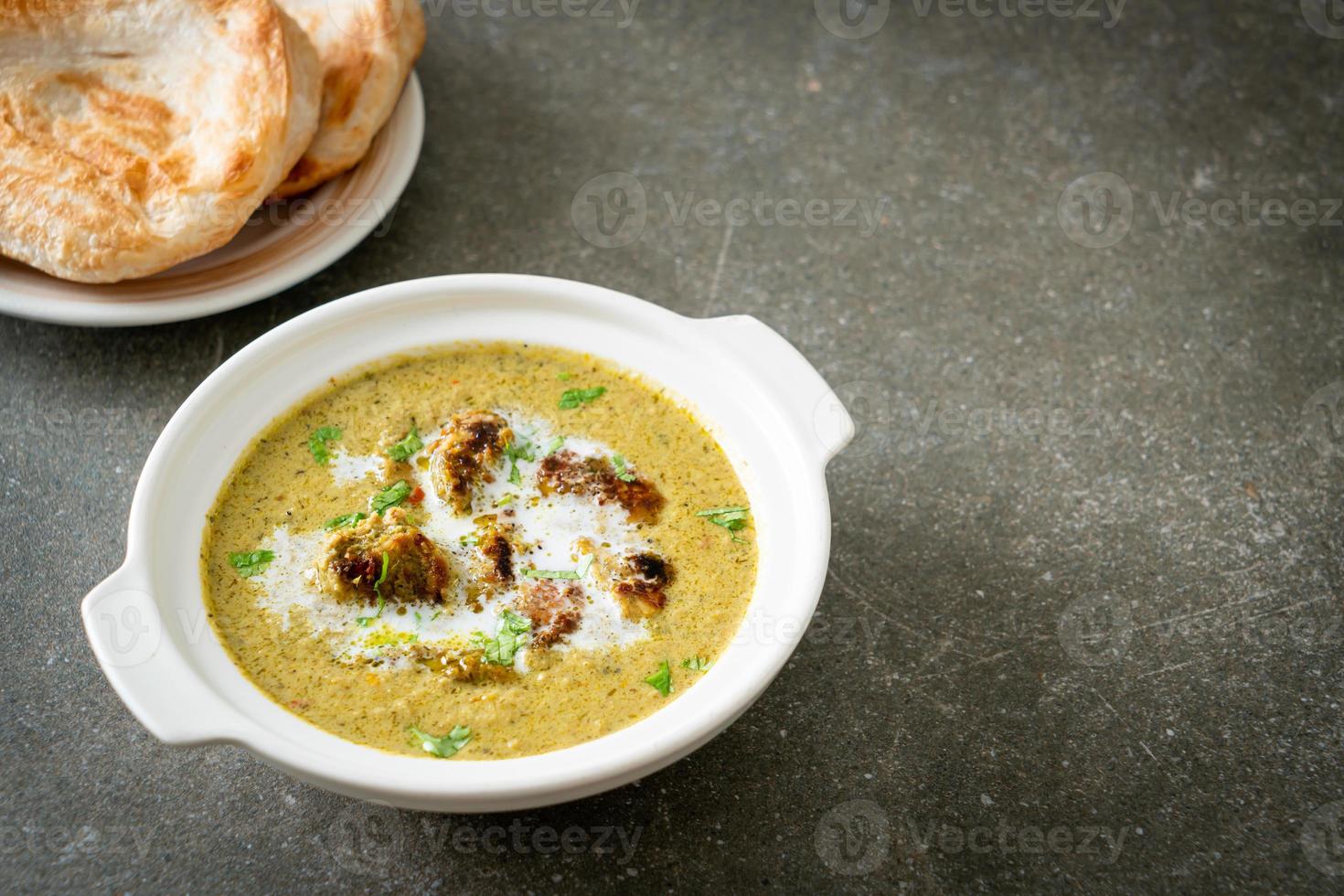 Afghani chicken in green masala curry or Hariyali tikka chicken hara masala with roti or naan bread photo