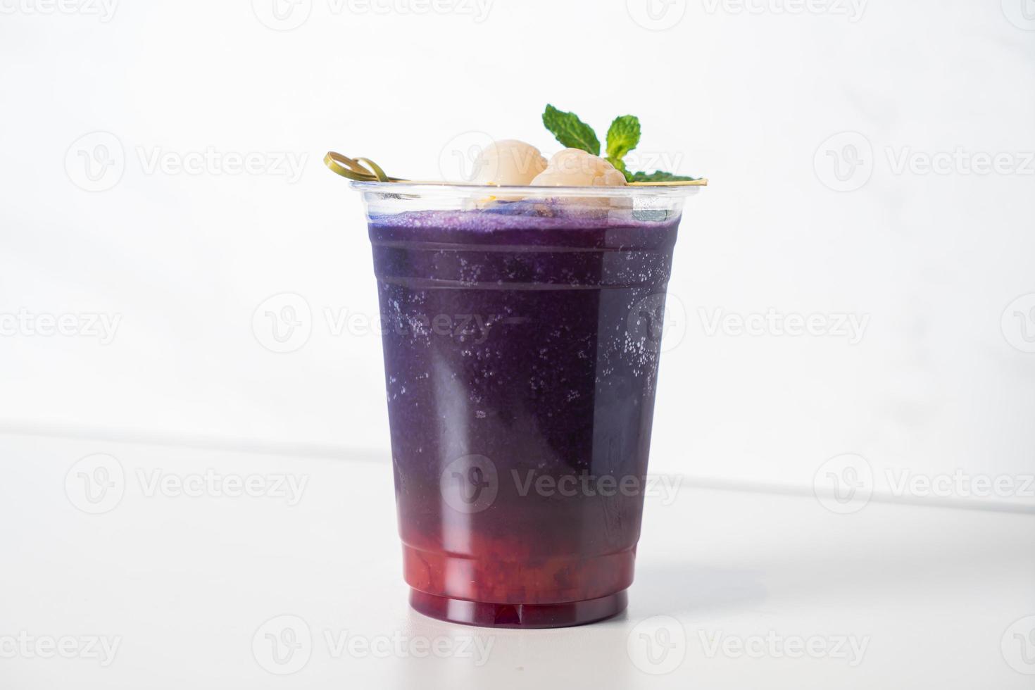 strawberry syrup and butterfly pea juice with fresh lychee on top photo