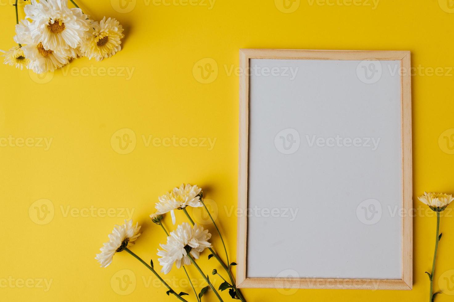 Photo frame with flowers on yellow background