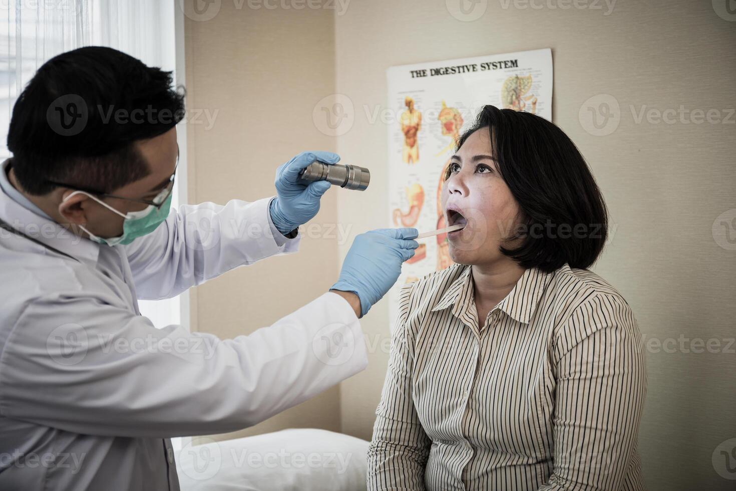 doctor in white uniform gown checkup patient's mouth with flashlight photo