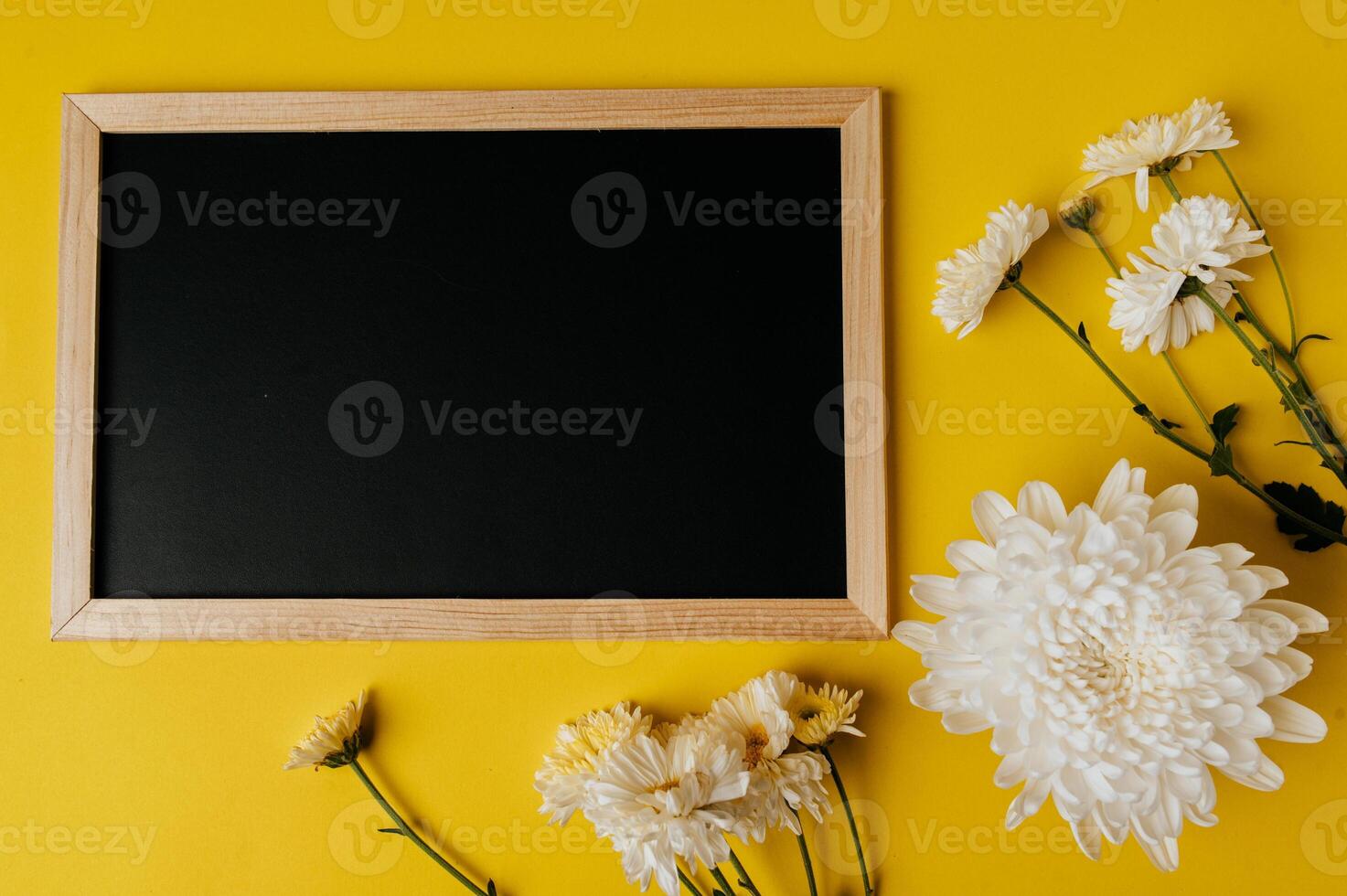 chalkboard on yellow background decorated with flowers photo