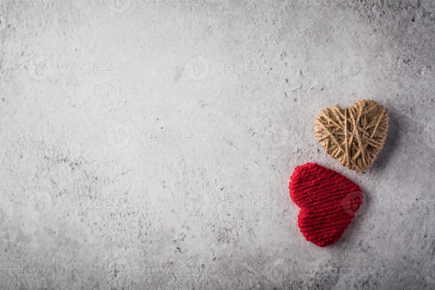 photo red yarn heart shaped on the wall background