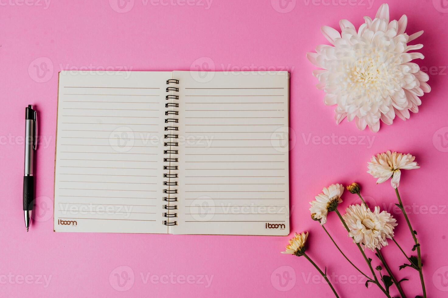 notebook and pen on pink background photo