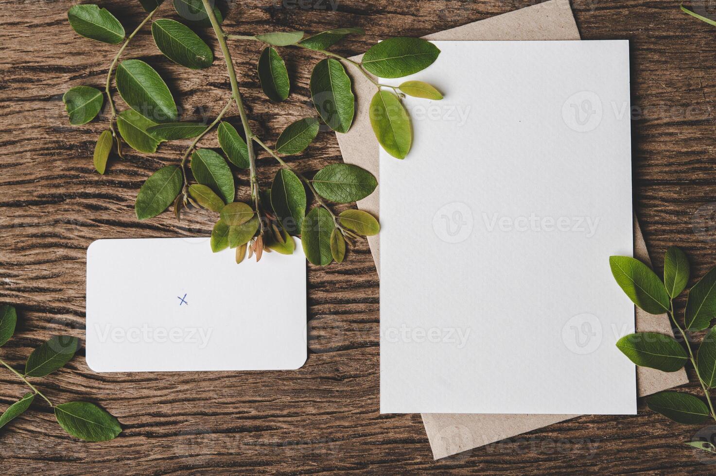 blank piece of paper with an envelope on  wooden background photo