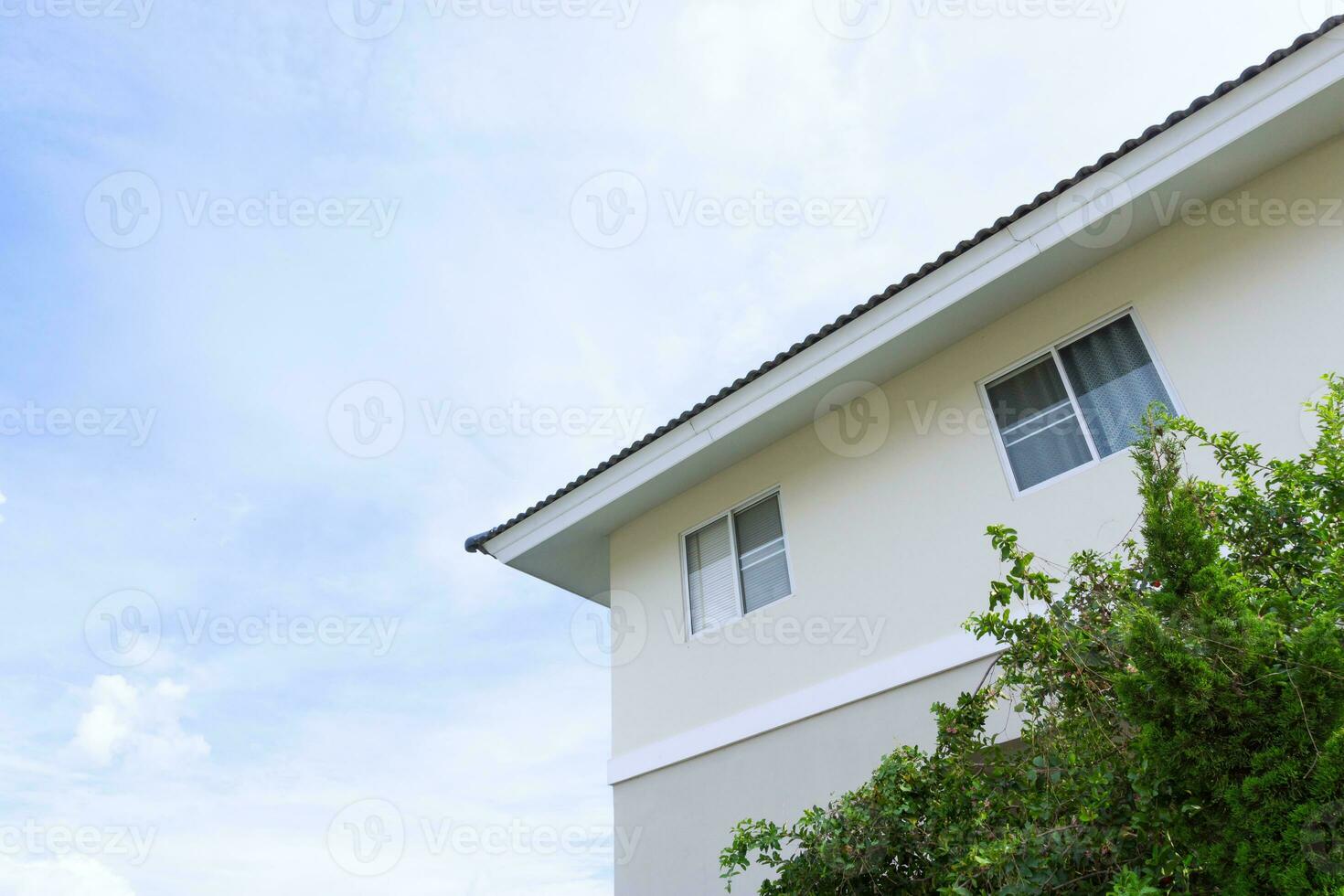 House roof with large windows on blue sky background,generic view to facade of a new modern building with blue sky photo