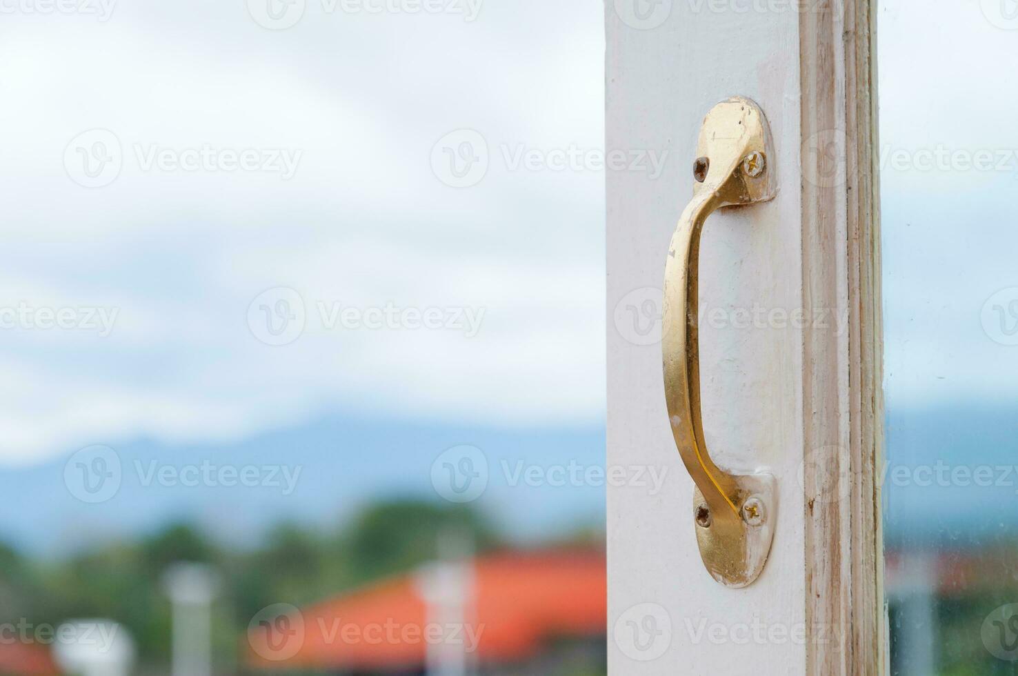 Golden Stainless steel vintage style handle on painted wooden white window, Furniture handles photo