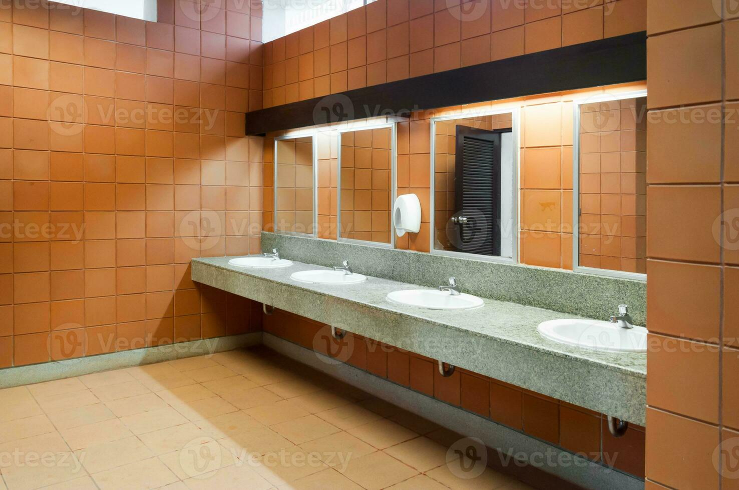 Interior of public clean toilet in a shared toilet there is a wide selection of sinks with mirrors photo