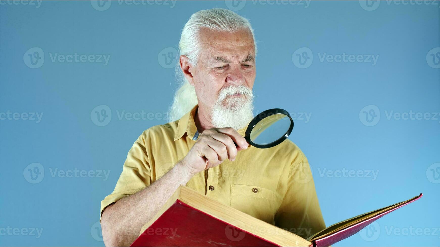 antiguo hombre mirando a libro con aumentador vaso foto