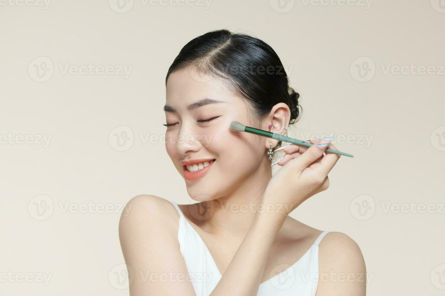Young pretty brunette lady making make up with brush for eyes isolated photo