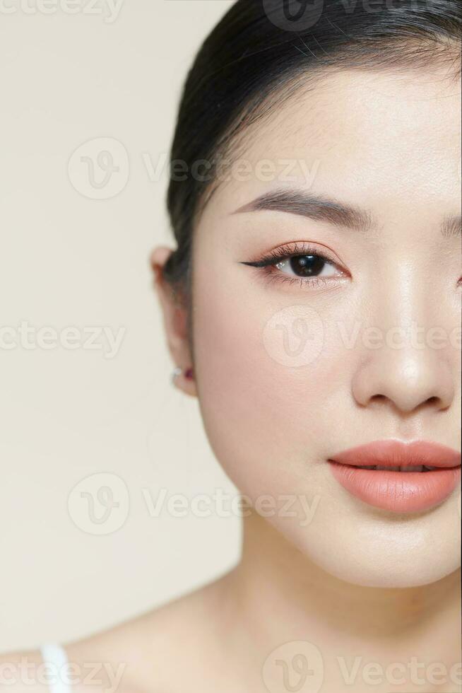 Beautiful young Asian woman with clean fresh skin on brown background photo